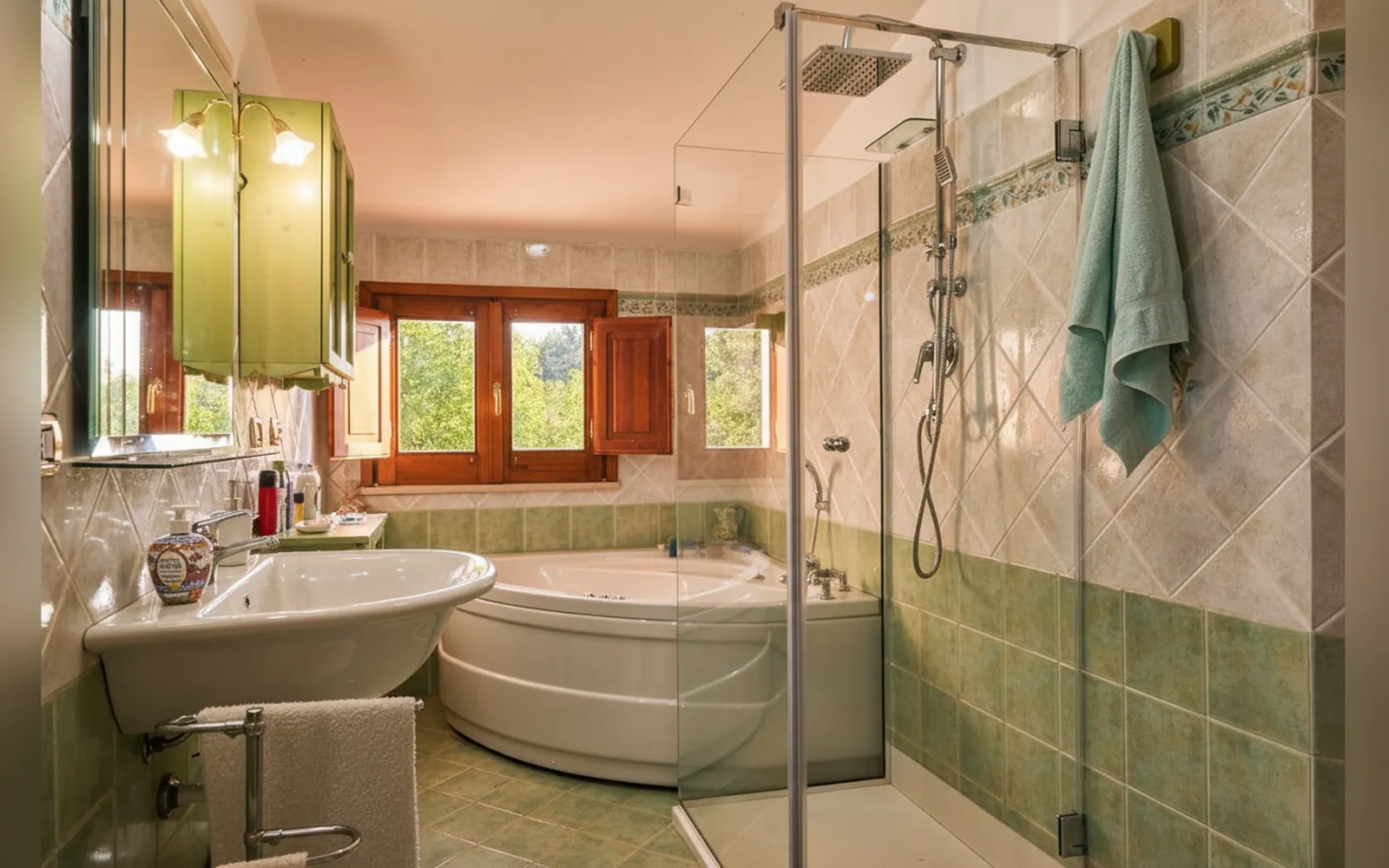 Il bagno con la vasca idromassaggio angolare e la doccia in vetro